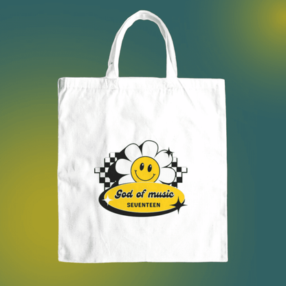 Seventeen god of music canvas tote bag front view, featuring a retro design with a smiley flower design.